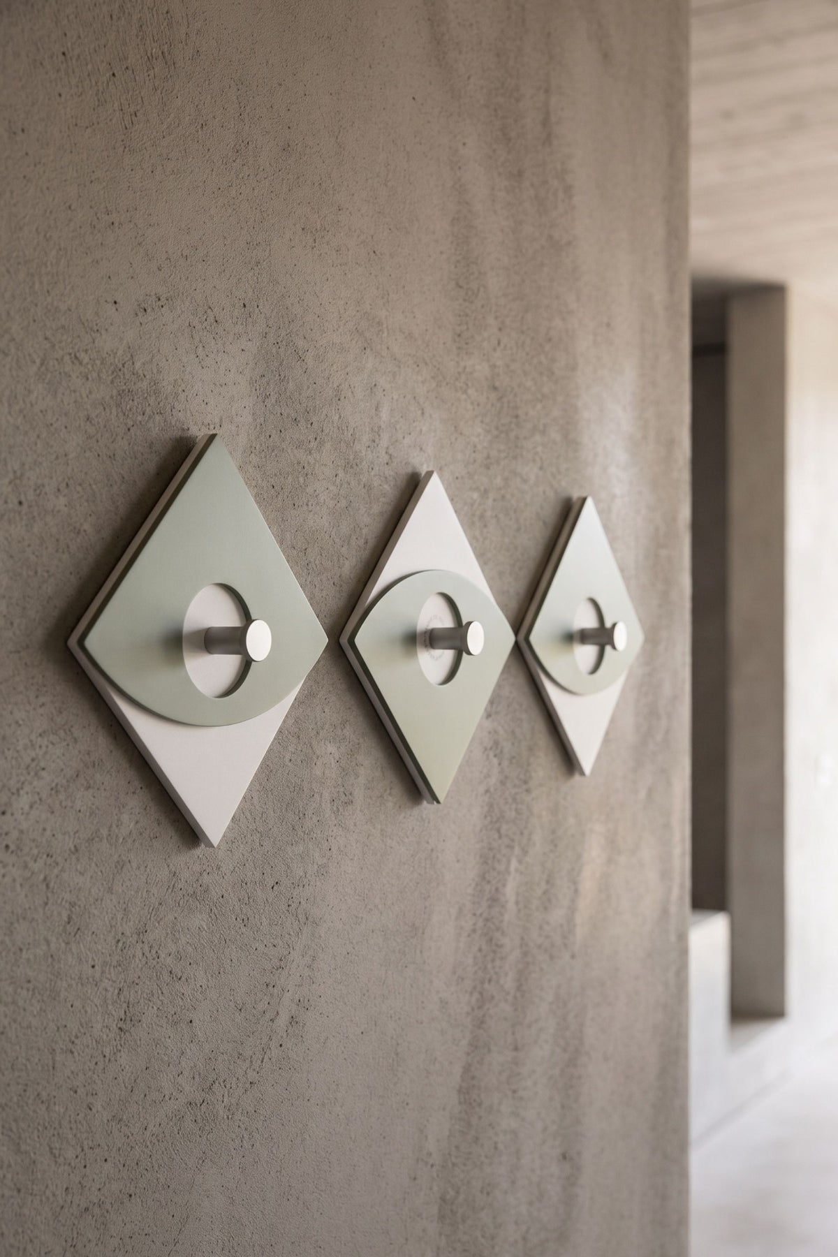 Eleonora wall-mounted coat rack in sage green, three hooks in a contemporary entrance