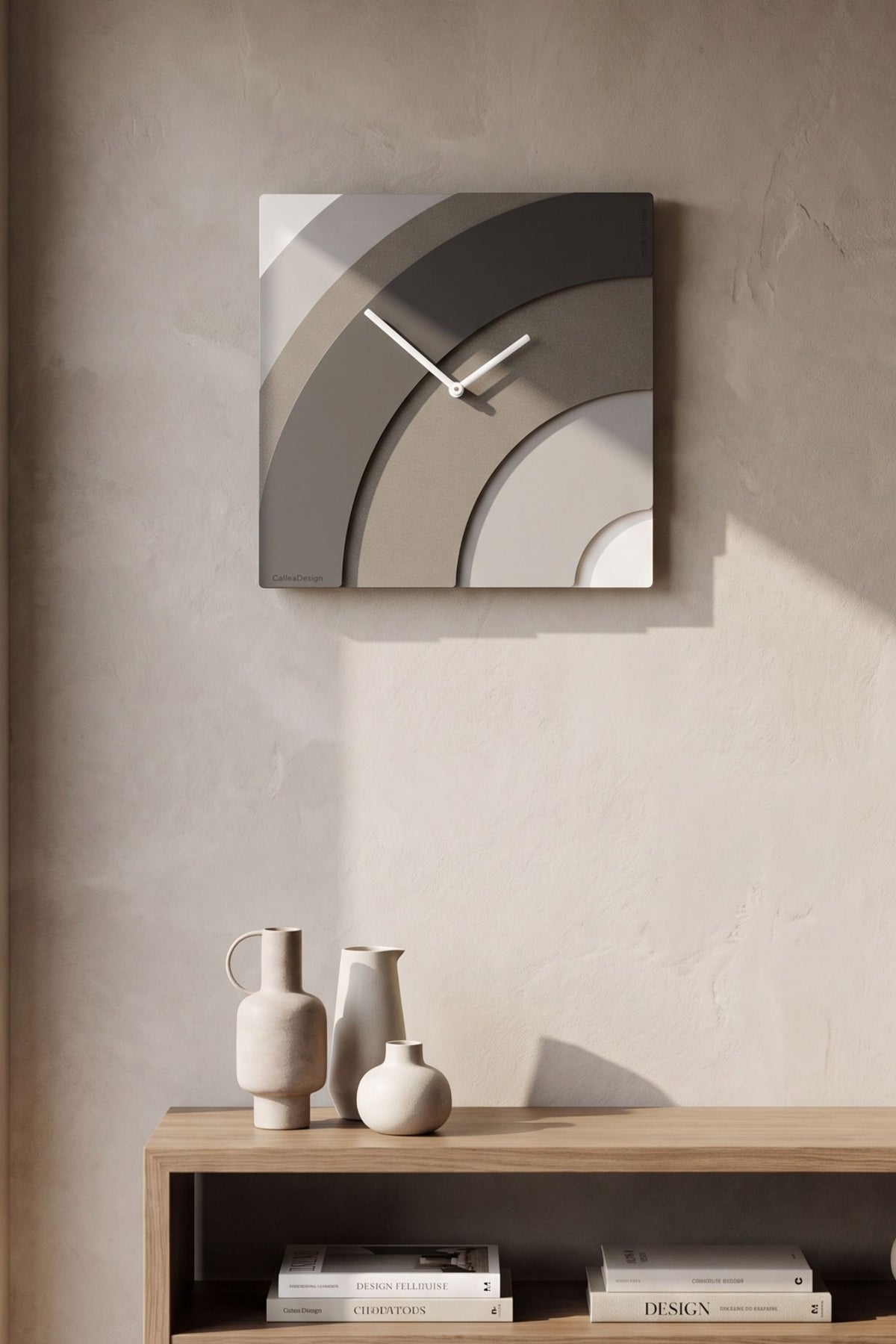 CalleaDesign Waves wall clock with layered curved design above a wooden console in a neutral contemporary interior